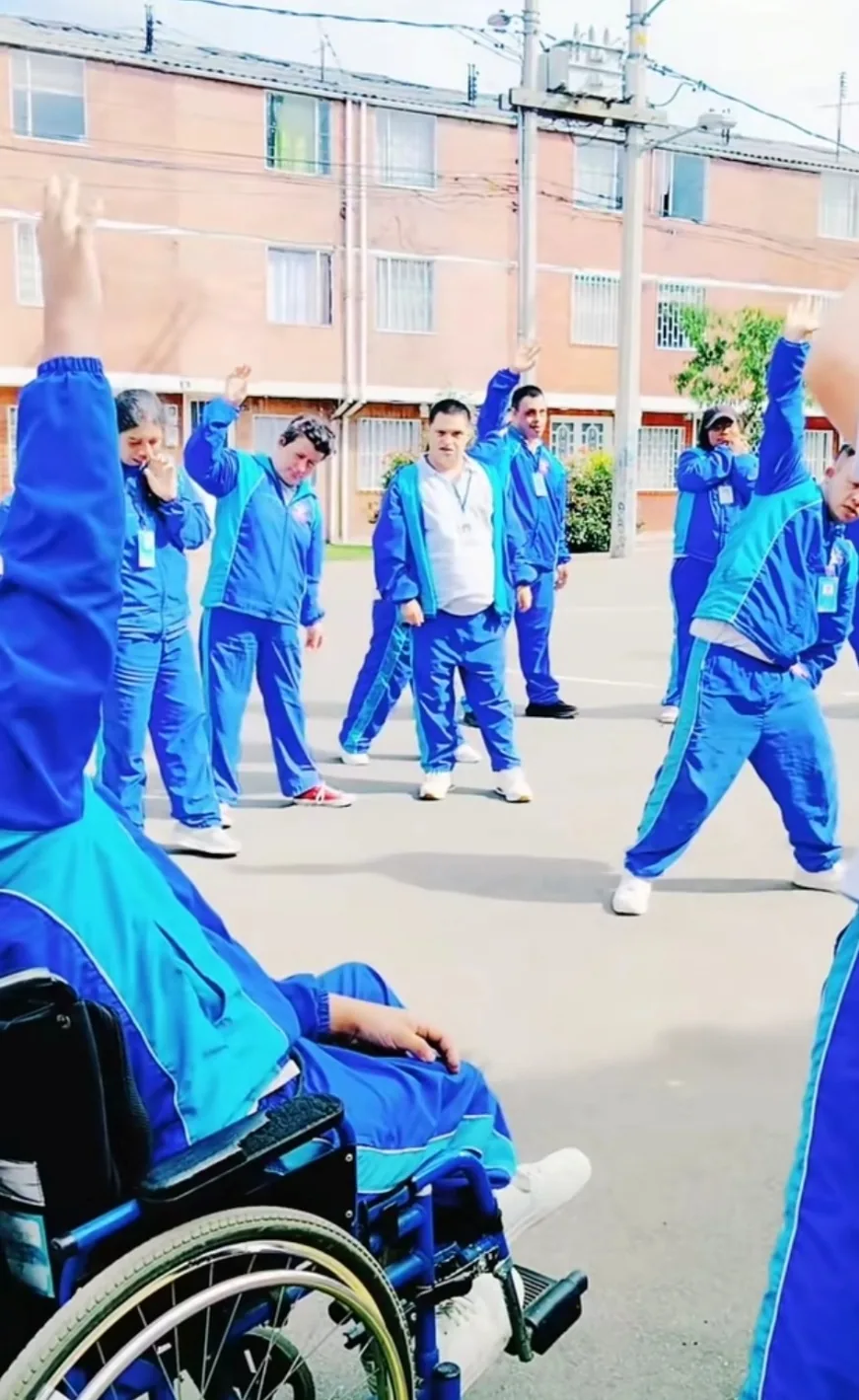 Jóvenes con sudadera azul haciendo ejercicio en círculo en una cancha