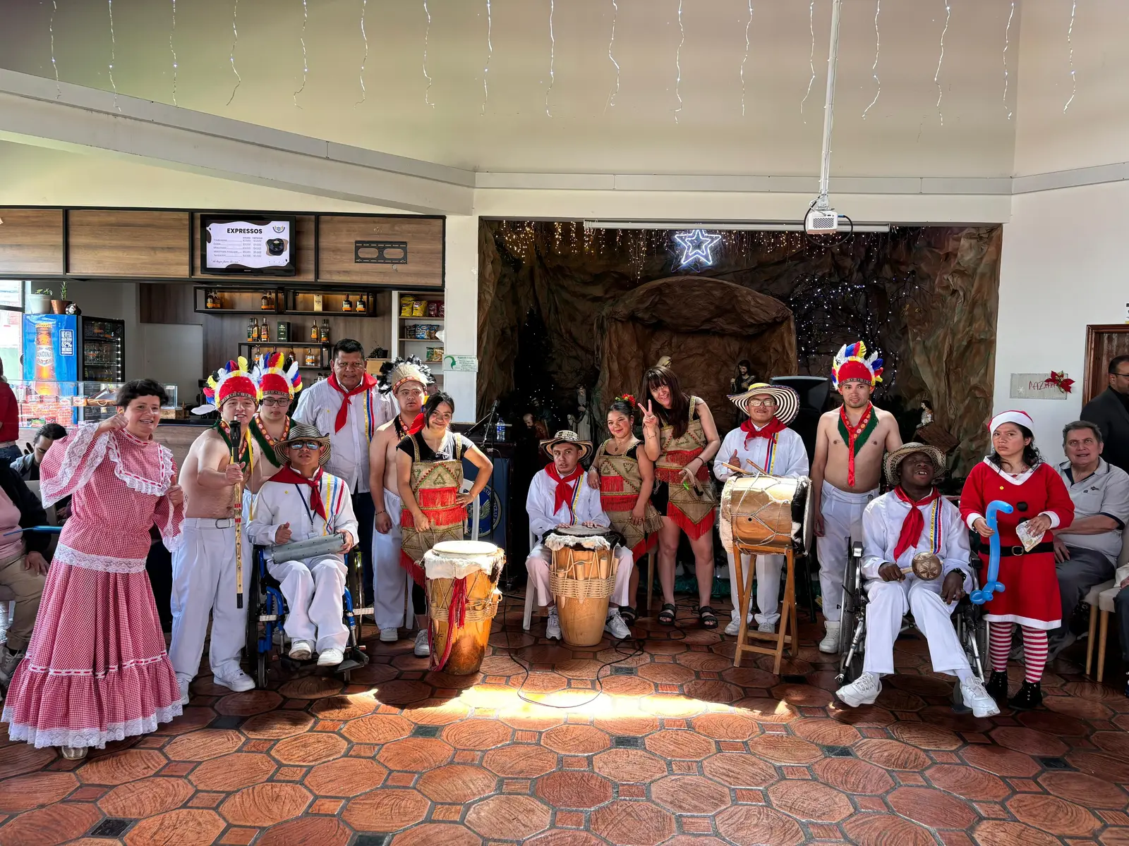 Grupo de gaitas y tambores con vestuario tradicional, penachos y polleras, junto a sus tambores