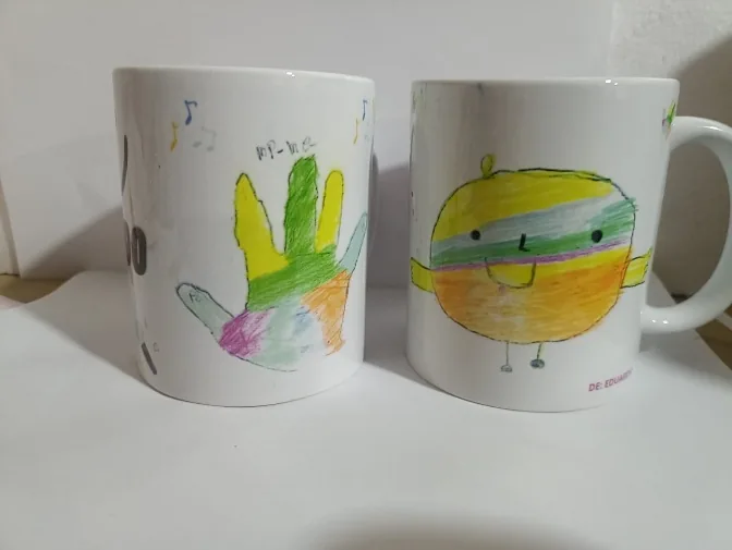 Dos pocillos blancos decorados con dibujos hechos a mano